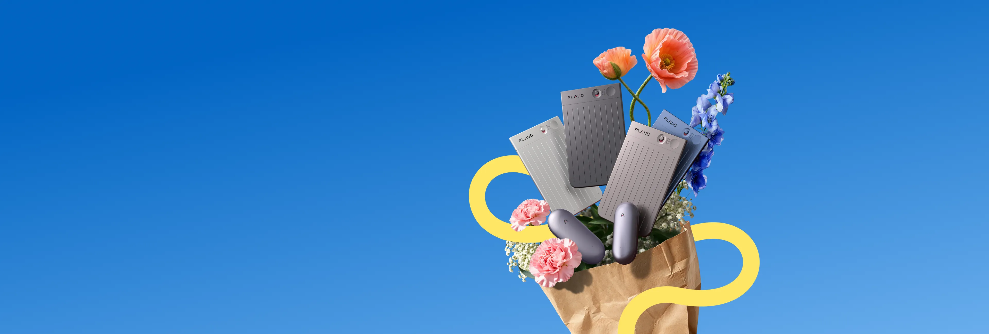 Several silver Plaud Note and Plaud NotePin devices are arranged with colorful flowers spilling from a brown paper bag agains