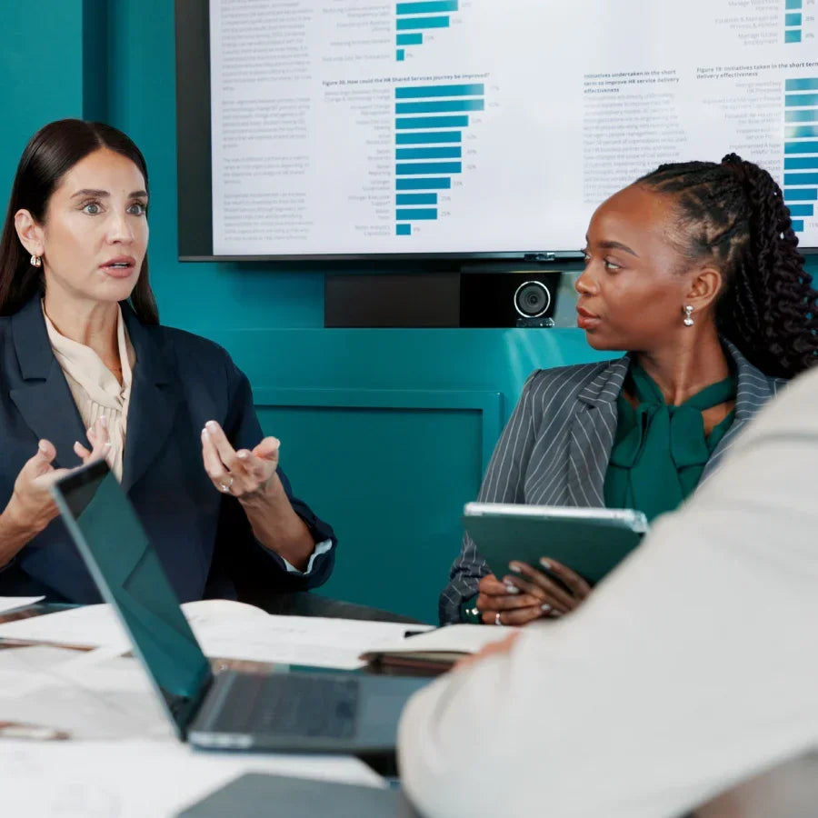 Colleagues discussing meeting notes and data around a conference table